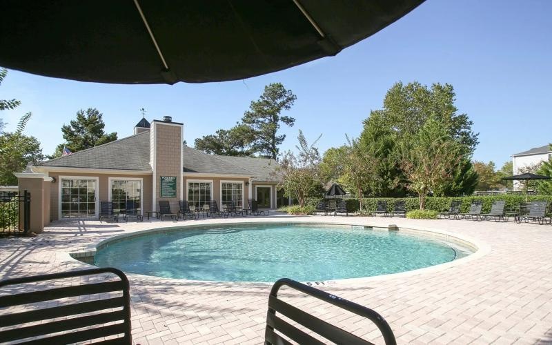 umbrella shaded seating next to pool