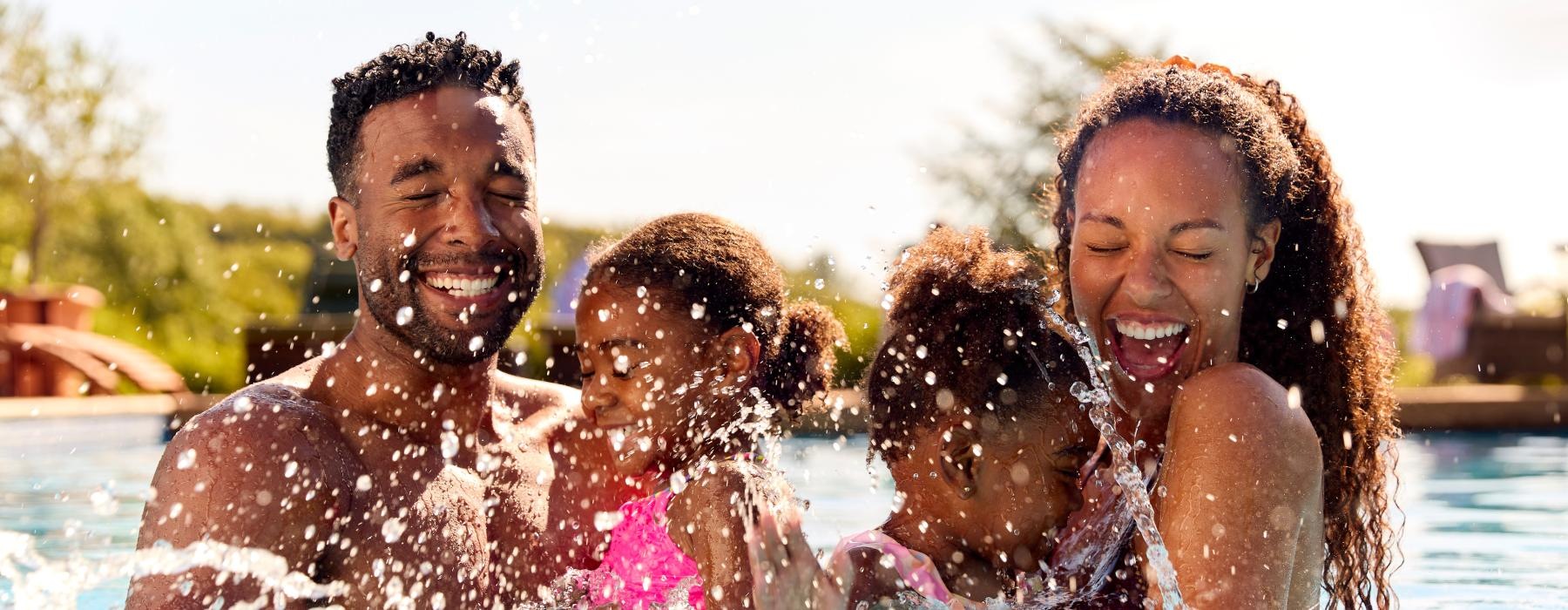 family with kids splash in a pool