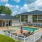 gated outdoor pool area with chairs and tables